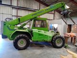 a green crane that is sitting in a building