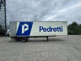 Le camion de livraison est garé sur un parking sous un ciel nuageux.