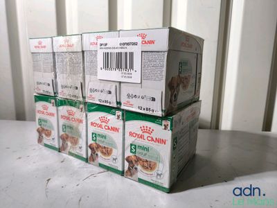 des boîtes de nourriture pour chiens empilées les unes sur les autres sur une table