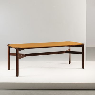 une table basse avec un plateau en bois posé sur un piètement blanc