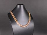 un collier à chaîne en or sur un mannequin, sur fond noir