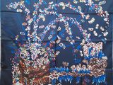 an image of a blue silk scarf with a picture of a tree and flowers