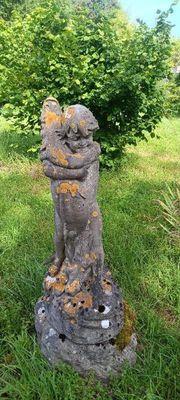 une statue représentant un chat assis dans l'herbe