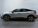 the silver car is parked in a large room with a white wall