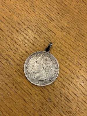a silver coin sitting on top of a wooden table