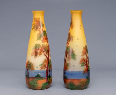 two vases with trees painted on them sitting side by side