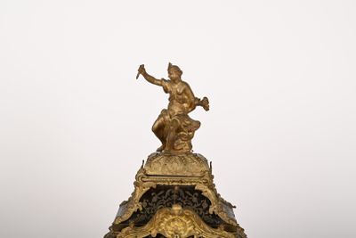 a statue of a man holding a hammer on top of a clock