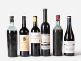 several bottles of wine are lined up in a row on a white surface