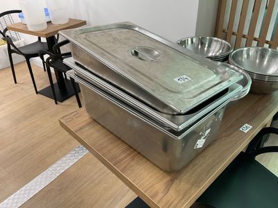 three pans sitting on a table with bowls on it