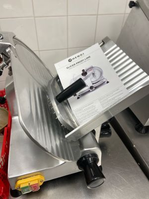 a meat slicer sitting on a counter in a kitchen