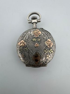 une montre de poche ancienne en argent, ornée d'un motif floral sur le cadran