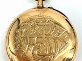 an image of a gold pocket watch sitting on a white surface