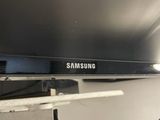 a black samsung tv sitting on top of a shelf