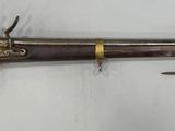 un gros plan d'un fusil accroché au mur, à côté d'un couteau
