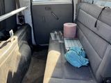 a seat in the back of a van with a bottle of water on the floor