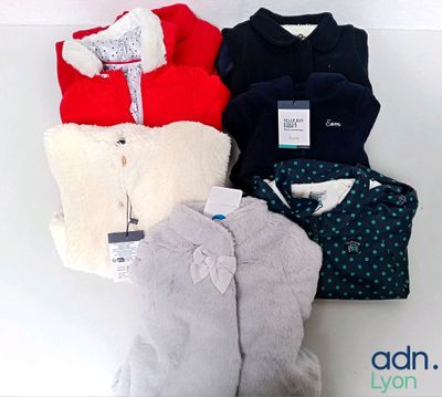 four pairs of sweaters are lined up on a white surface
