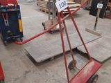 a red hand truck with a sign on it in a warehouse