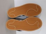pair of black and white shoes with brown soles on a white surface