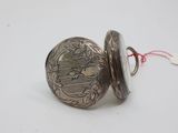 a close up of a silver pocket watch on a white surface