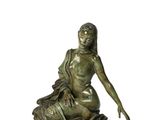 statue en bronze représentant une femme assise sur un rocher, les mains posées sur les genoux