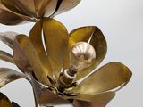 a metal sculpture of a flower with pearls on it