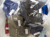 a lot of clothes in a plastic bag on the floor