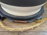 a white hat on a wooden table with a rope around it