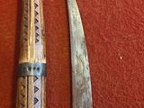 un couteau et une lame de couteau sur une surface rouge