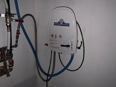 un chauffe-eau fixé au mur dans une salle de bains