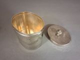 a silver container with a lid sitting on a table