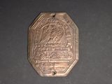 a small metal plaque with a picture of a man and a woman on it