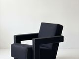 une image représentant une chaise noire posée sur un sol blanc
