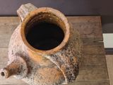 a small brown vase sitting on a wooden table