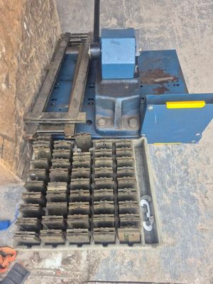 une machine posée par terre à côté d'un tas de briques