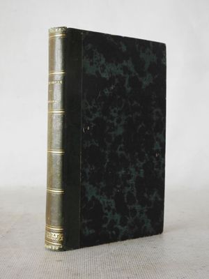 an old book sitting on top of a table next to a white wall