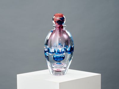 une bouteille en verre posée sur un socle