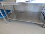 une table en acier inoxydable avec deux tabourets en plastique bleu