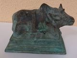 bronze statue of a cow with a harness on it ' s back
