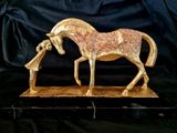 statue of a horse with a long mane on a black background
