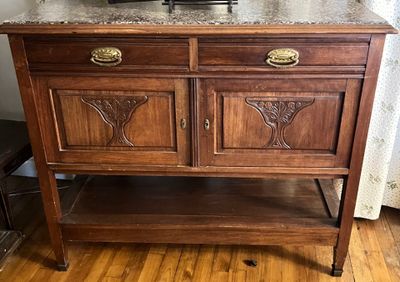 a wooden cabinet with a marble top on a hard wood floor