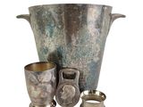 a silver vase and two cups sitting next to each other