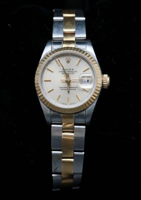 une photo d'une montre Rolex pour femme posée sur une surface noire