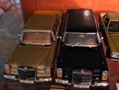 Plusieurs petites voitures sont alignées dans une vitrine.