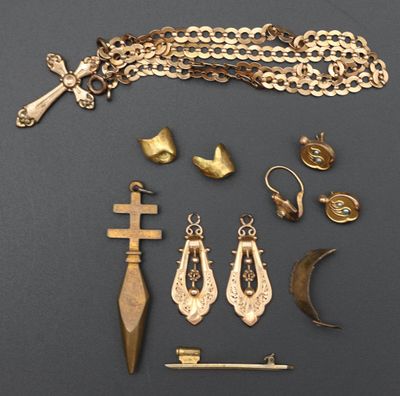 un assortiment de bijoux en or, comprenant notamment une croix, un poignard et d'autres objets