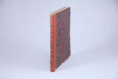 un vieux livre posé sur une surface blanche