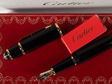 a red box with a black pen and a red box with a gold trim