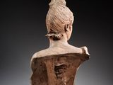 an image of a clay busturine of a woman on a gray background