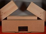two wooden boxes sitting on top of a red cloth