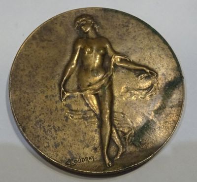 a close up of a gold medal with a woman holding a basket