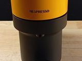 an orange and black coffee maker sitting on top of a wooden table